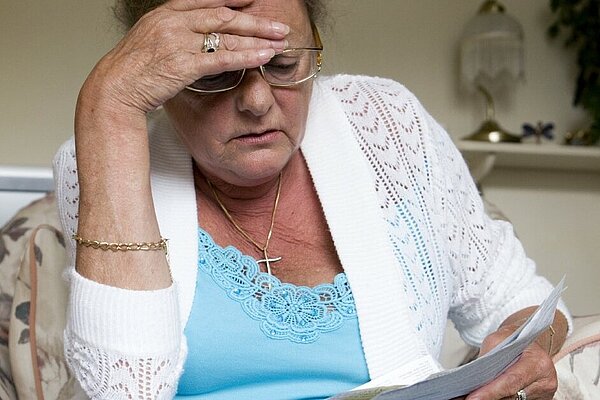 Woman looking concerned while reading a piece of paper